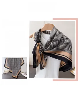 Detail van een zijden sjaal met pied-de-poule en elegant zwart en camel patchworkpatroon