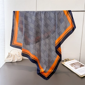 Luxe zijden vierkante sjaal met houndstooth patroon in marineblauw en oranje aan metalen rek