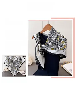 Détail macro d'un foulard en soie avec motifs de papillons jaunes et fleurs sur bord noir