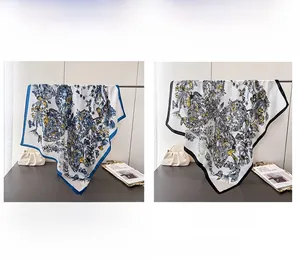Détail d'un foulard en soie avec imprimé fleurs et papillons en bleu et noir