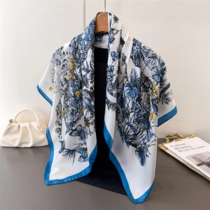 Élégant foulard en soie blanc avec imprimé fleurs et papillons bleus sur un cintre