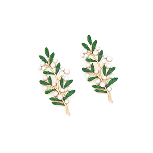 Macro shot of gold leaf earrings with green enamel and white pearls in olive branch design
