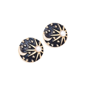 Macro detail of celestial earrings featuring blue enamel with sun, moon, and pearl accents