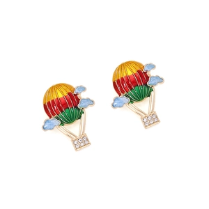 Macro detail of enamel hot air balloon earrings with colorful stripes and crystal basket