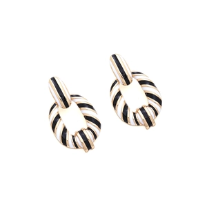 Detailed view of luxury black and white checkered enamel earrings with gold plating