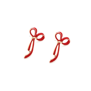 Dettaglio di orecchini a fiocco in smalto rosa con eleganti bordi in metallo dorato su bianco