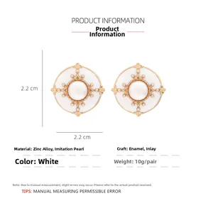 Detail view of round white enamel stud earrings with 2.2 cm size and alloy pearl details