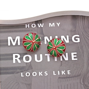 Boucles d'oreilles vintage en émail rouge et vert avec bordure dorée sur magazine