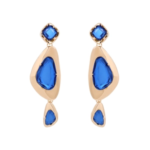 Detailed view of geometric drop earrings with blue rhinestones in a gold finish setting