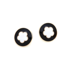 Orecchini tondi dorati con smalto nero e motivo floreale bianco su sfondo bianco neutro