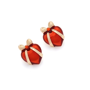 Close-up of red heart earrings with gold bows and sparkling orange rhinestones
