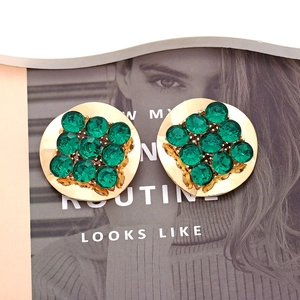 Detail of vintage gold alloy earrings with 3x3 green crystal stones and wavy edges
