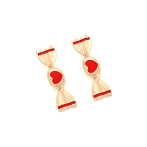 Détail de boucles d'oreilles dorées en forme de bonbon avec cœurs rouges et rayures