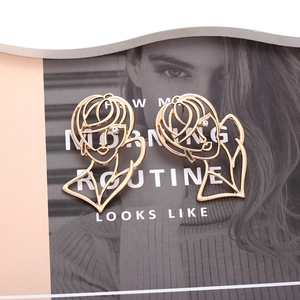 Boucles d'oreilles portrait en or ajouré avec visage abstrait minimaliste et strass