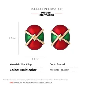 Detail view of vintage oval enamel earrings in red and green with gold X-shaped cross