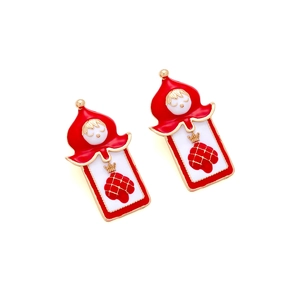 Detailed view of red enamel soldier earrings with gold crown and poker card aesthetics