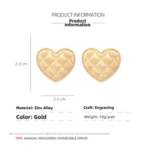 Detail view of gold-tone heart earrings showing diamond lattice texture and size specs