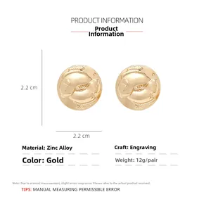 Detail of round golden alloy stud earrings with engraved Pisces pattern and 2.2cm diameter
