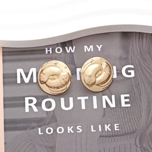 Retro golden round stud earrings featuring embossed koi fish and starry patterns