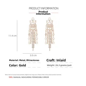 Detail view of long gold tassel earrings with crystal rhinestones showing 11.4cm length