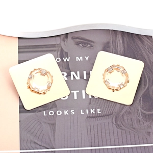 Close-up of golden square earrings with octagonal champagne crystal and rhinestones