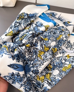 Détail macro d'un foulard en soie avec motifs de papillons bleus et fleurs sur satin