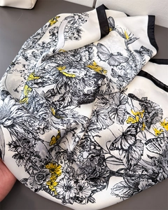 Détail d'un foulard en soie avec motif floral et papillon jaune sur tissu drapé
