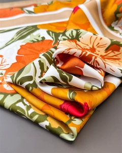 Detail of luxury silk-like scarf featuring floral prints and smooth satin texture