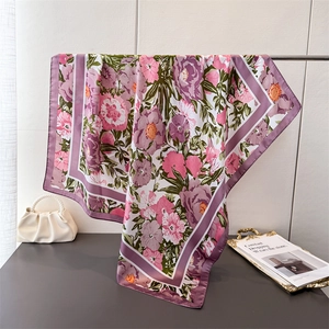 Elegant floral silk square scarf in pink and purple with a smooth draped texture