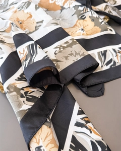 Detailed macro view of the hand-rolled edges and glossy silk texture on the floral scarf