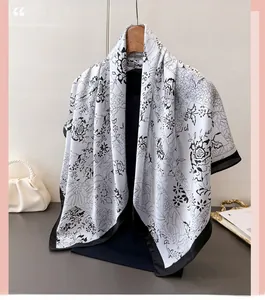 Detail of elegant black and white floral print silk scarf with fine black hem on hanger