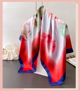 Close-up of elegant floral silk scarf draped on a wooden hanger with luxury props