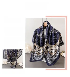 Close-up of dark blue silk scarf with golden Baroque patterns and smooth satin texture