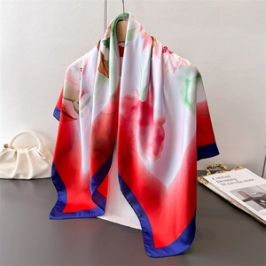 Macro detail of silk-like floral scarf draped over a wooden hanger with luxury props