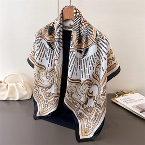 Elegant baroque print silk scarf with golden scrolls on a wooden hanger display