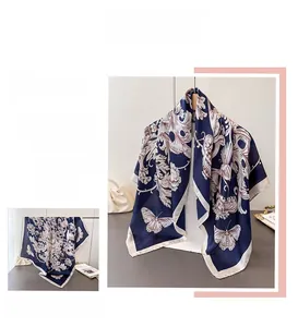 Detail of vintage floral and butterfly patterns on a navy blue faux silk large scarf