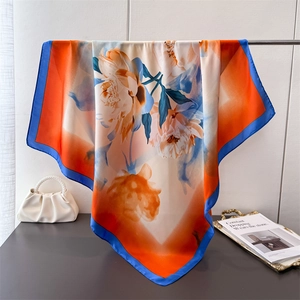 Elegant silk-like square scarf featuring peony prints in vibrant orange and deep blue colors