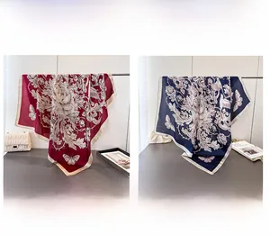 Detail view of large floral print silk scarves in red and navy blue with rolled edges
