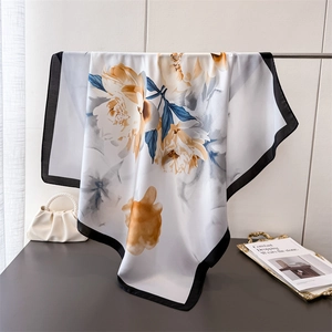 Elegant silk scarf featuring orange peonies and blue leaves with a black border