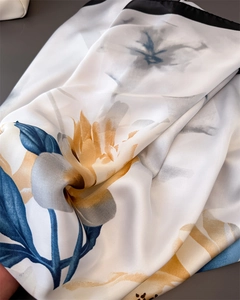 Detailed macro view of the silky texture and elegant blue peony floral print on a scarf