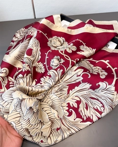 Detailed texture of burgundy silk scarf featuring elegant floral and crane patterns
