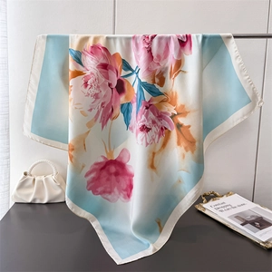 Satin silk scarf with elegant peony flower print hanging on a metal rack