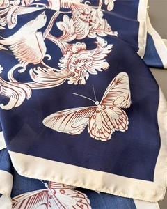 Detail of navy blue silk scarf featuring elegant white butterfly and floral prints