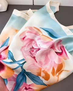 Detail of silk scarf with peony floral print showing smooth satin texture and vibrant colors