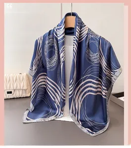 Close-up of geometric abstract print silk scarf with beige rings on a blue background
