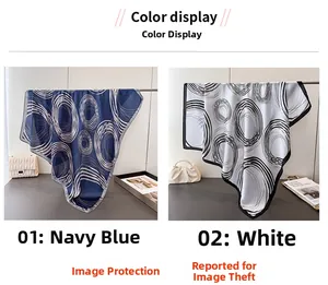 Detail view of navy and white silk-like scarves featuring modern geometric abstract patterns