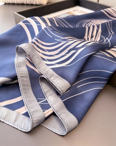 Close-up of elegant dark blue silk scarf with white streamlined pattern and fine edge stitching