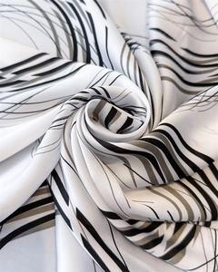 Close-up of geometric silk scarf with abstract waves and elegant satin texture