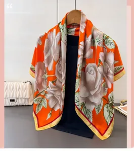 Detailed view of large orange satin scarf with white rose floral print on a hanger