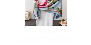 Detailed view of elegant blue satin scarf with pink floral patterns and orange edges